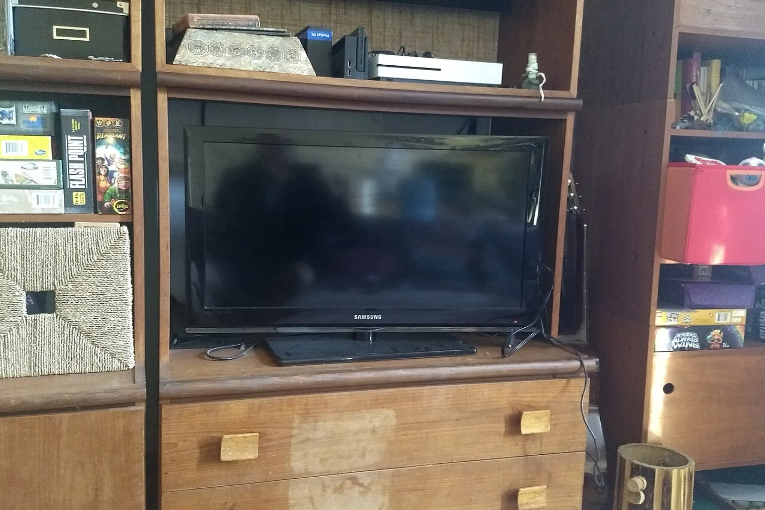 A flat screen television standing on a wooden cabinet in a home